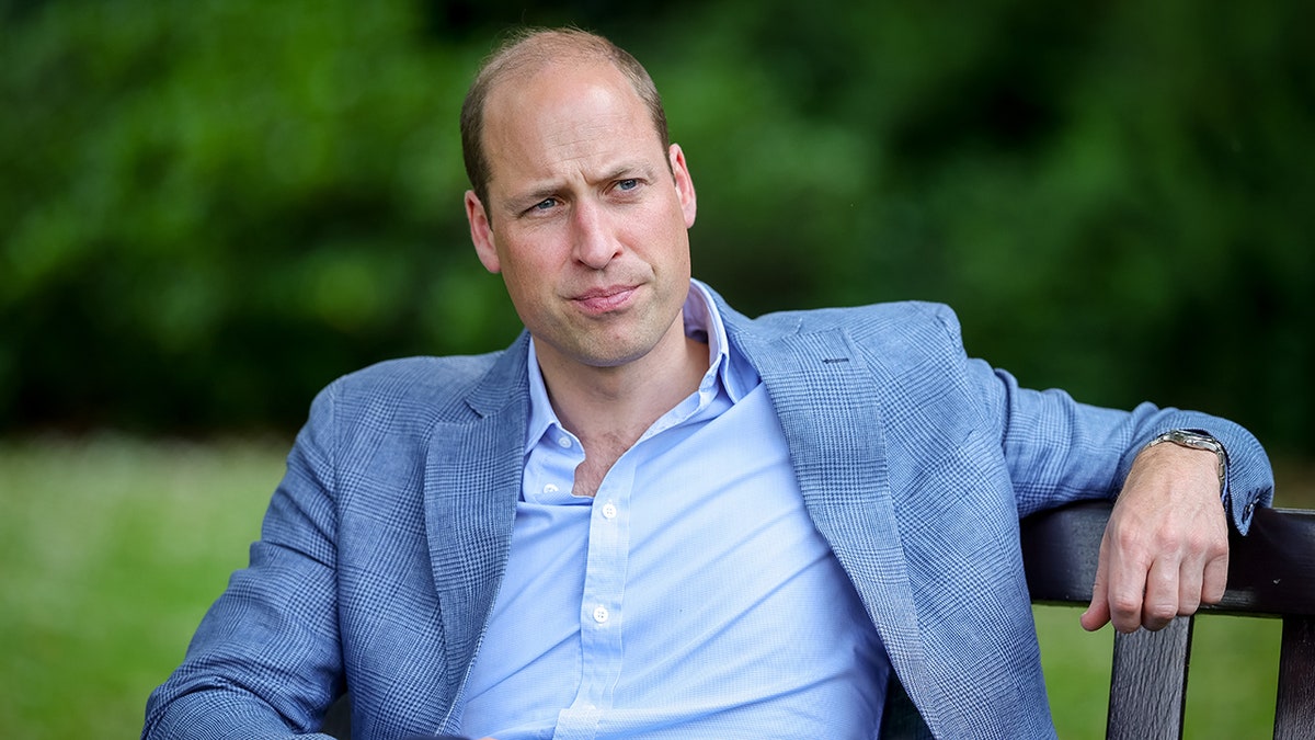 Close-up of Prince William wearing a light blue jacket and matching shirt.