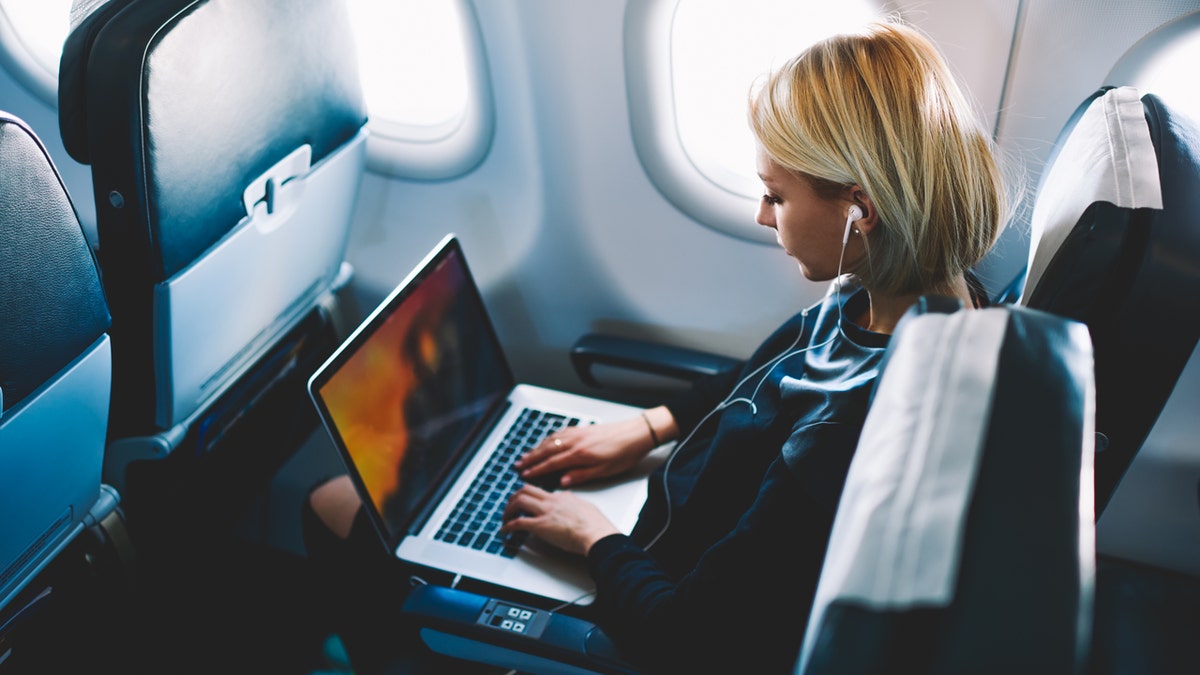 Woman using laptop on plane