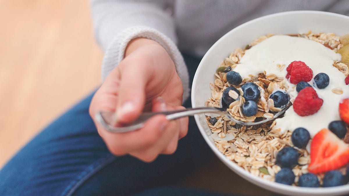 Bowl of healthy breakfast includes baggers, blueberries, granola and yoghurati.