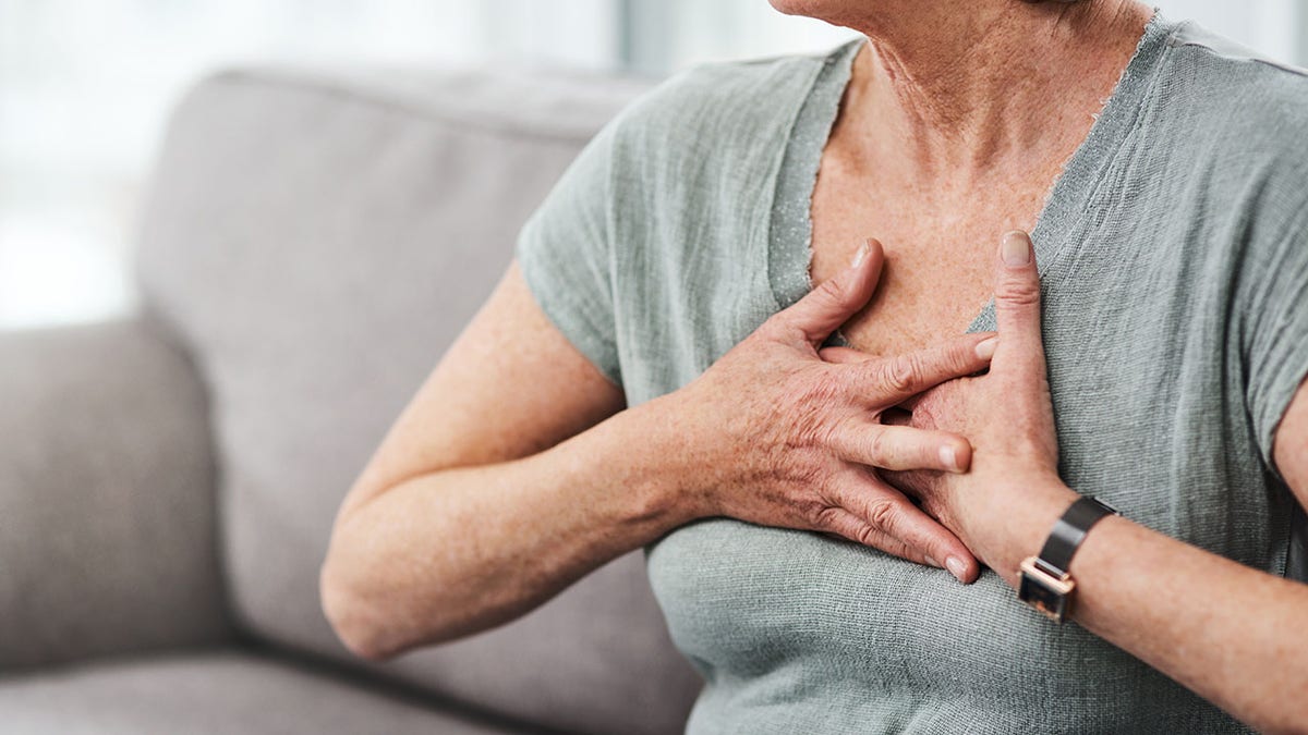 woman puts hands on heart