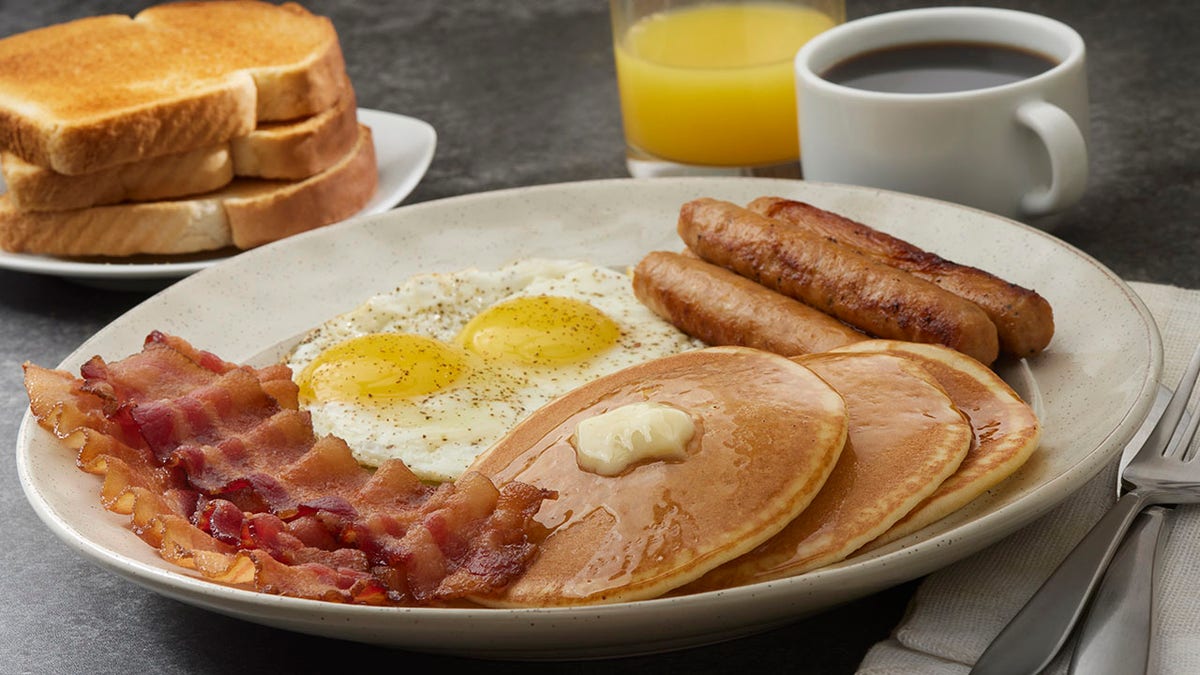 Breakfast with pancakes, bacon, sausage, eggs and toast