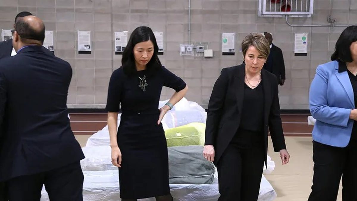 Boston Mayor Michelle Wu, left, and Massachusetts Gov. Maura Healey visit the Melnea A. Cass Recreational Complex, which was being used to house more than 300 migrants.