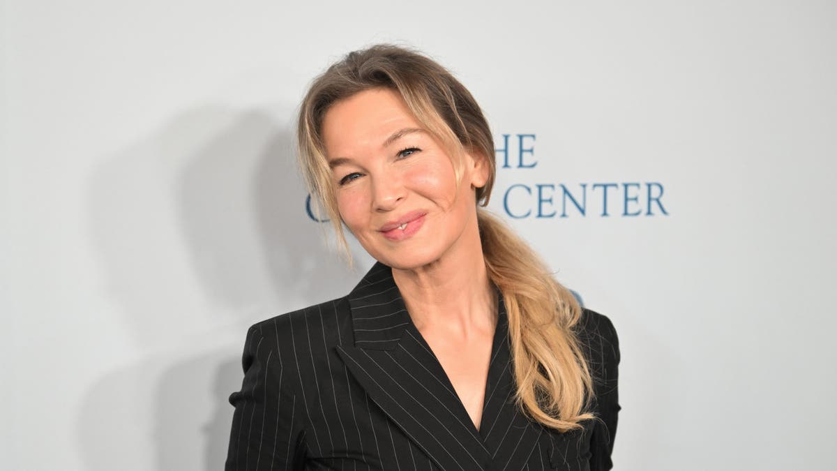 Renee Zellweger posing connected  reddish  carpet