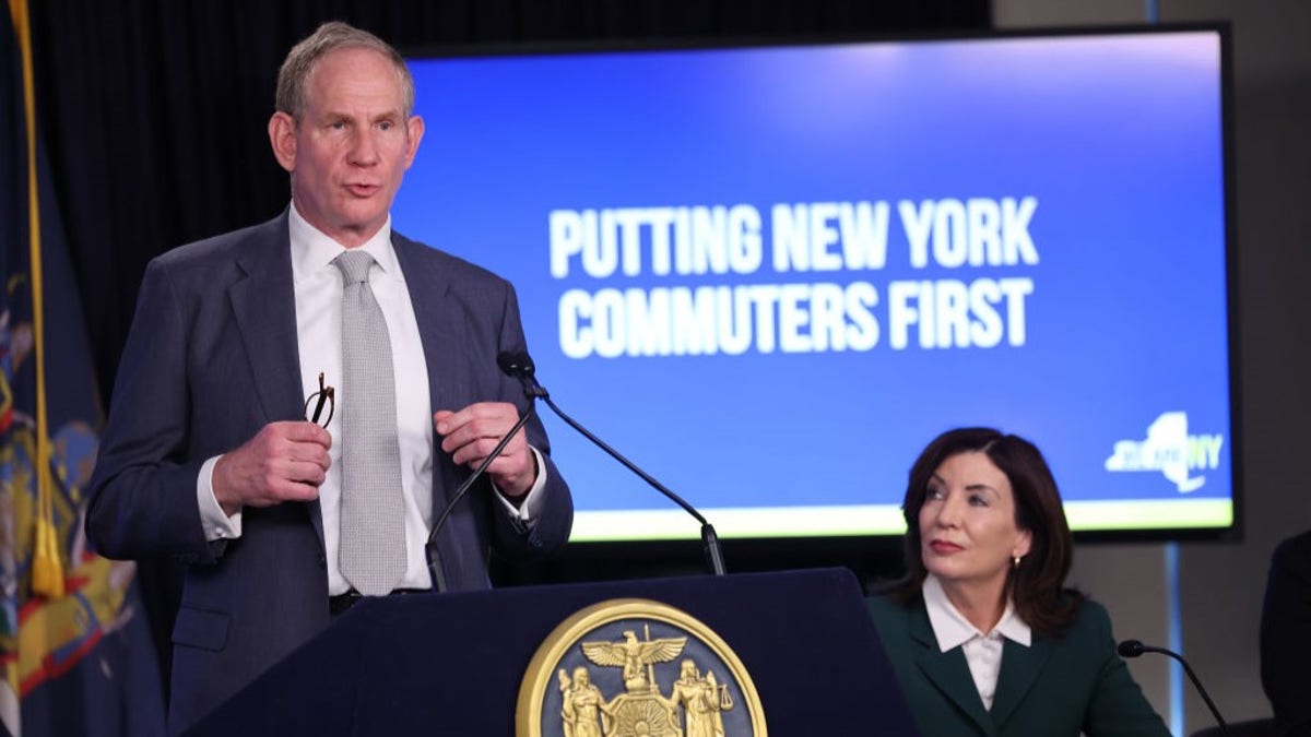 Mr. Hochul, background right, Mr. Janno Lieber, left