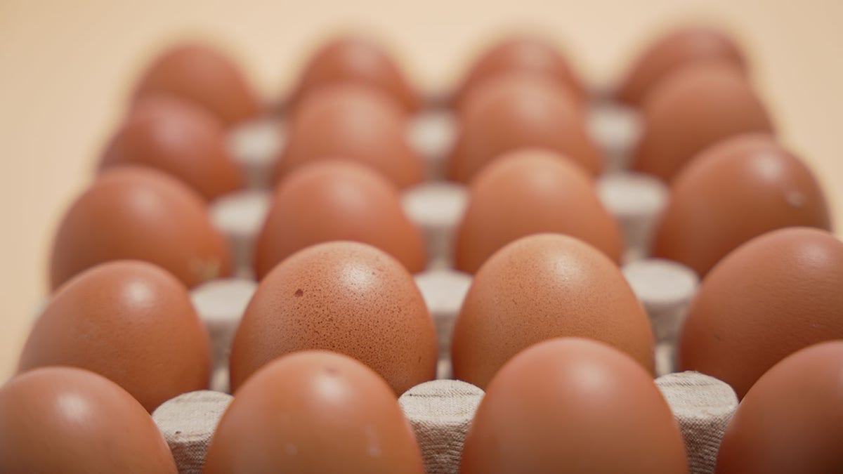 A close -up of a dozen eggs in a box.