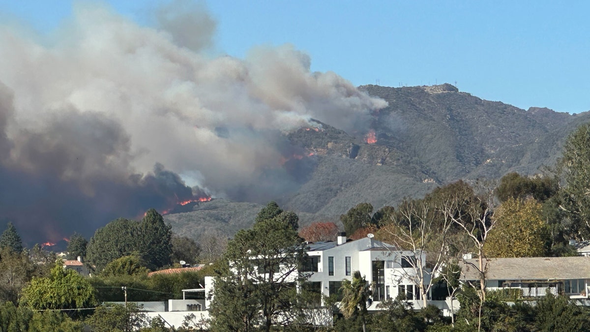 Flame and smoke from the Pacific Palisades fire can be seen on the hills behind homes in Santa Monica, Calif. Tuesday Jan. 7, 2025 (San Francisco Chronicle via Getty Images)