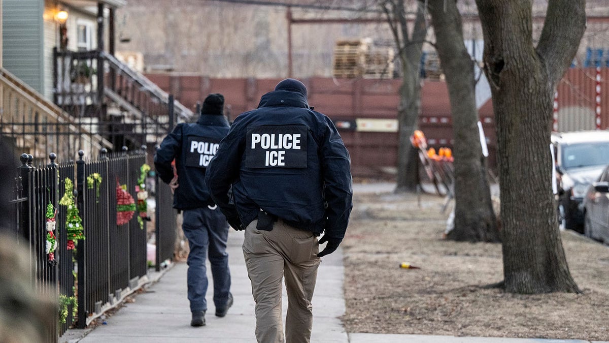 two ICE agents walking down street