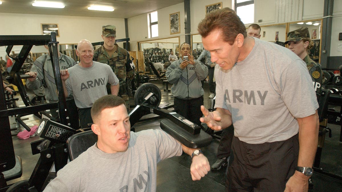 arnold schwarzenegger in gym with soldiers