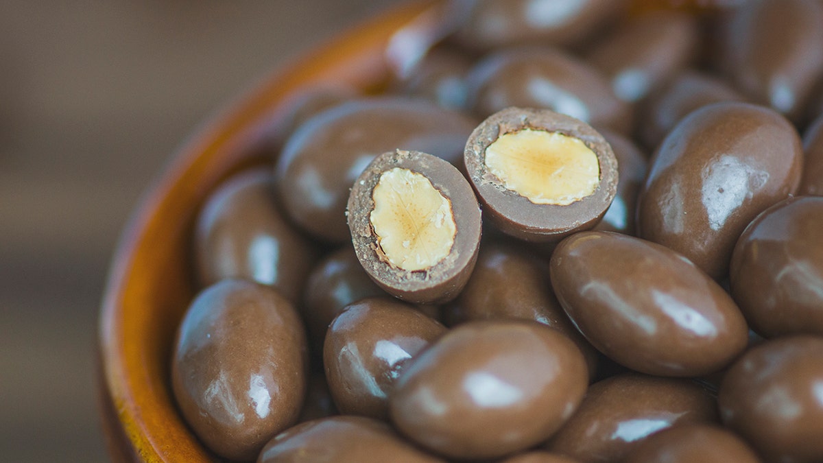 Stack of almonds dipped in milk chocolate.