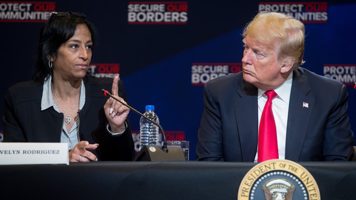 Evelyn Rodriguez seated next to then-President Trump at an anti-gang roundtable in New York