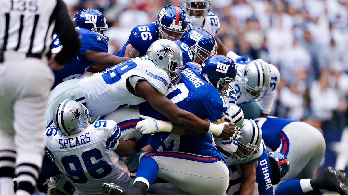 Eli Manning of the New York Giants dives for a first down against the Dallas Cowboys during the NFC Divisional playoff at Texas Stadium on January 13, 2008 in Irving, Texas. 