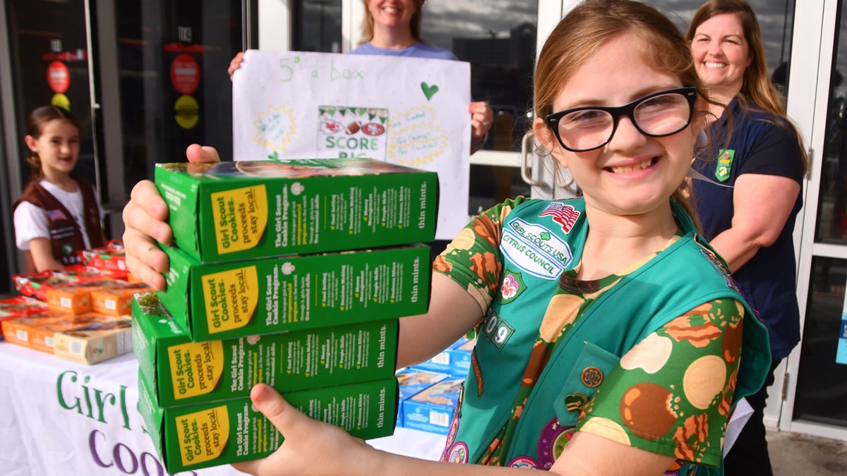 Girl Scout Isabella Tomerlin holds four boxes of Fine Mints after the sale.