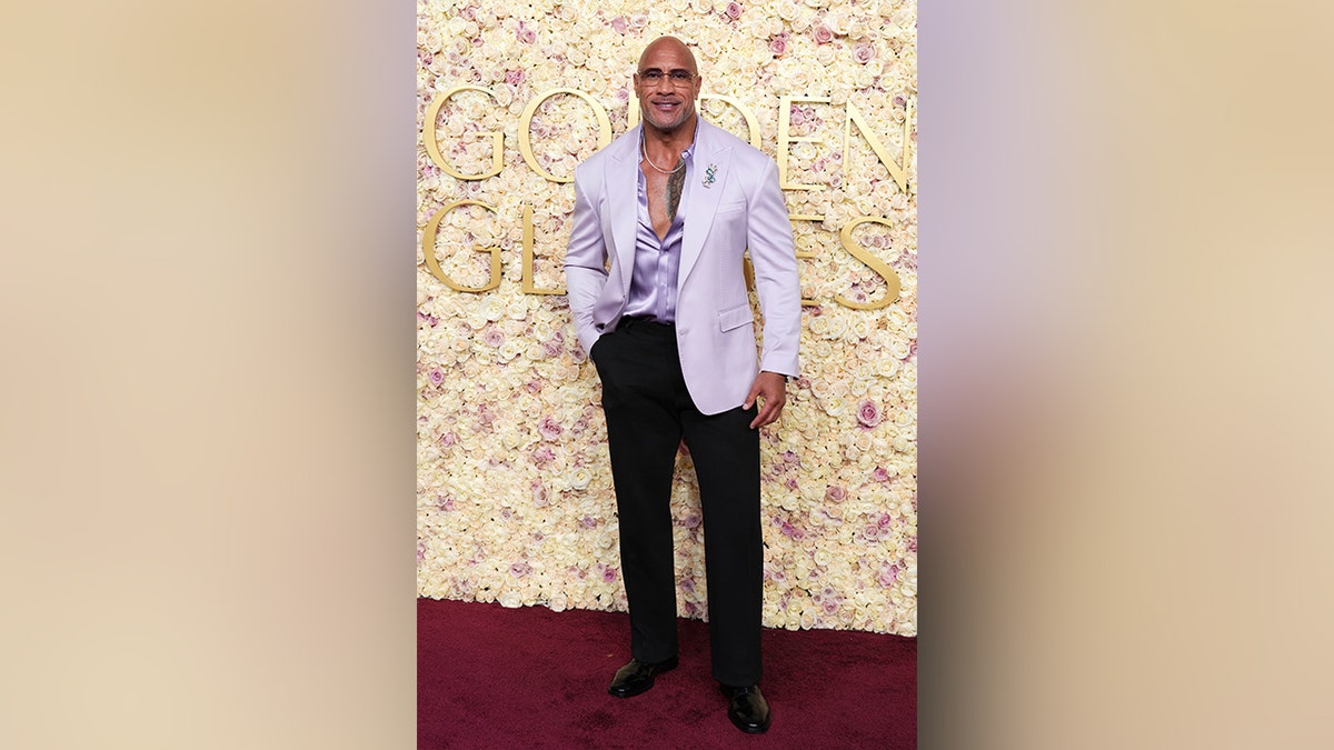 Dwayne Johnson got playful on the red carpet in a purple suit jacket and matching dress shirt.