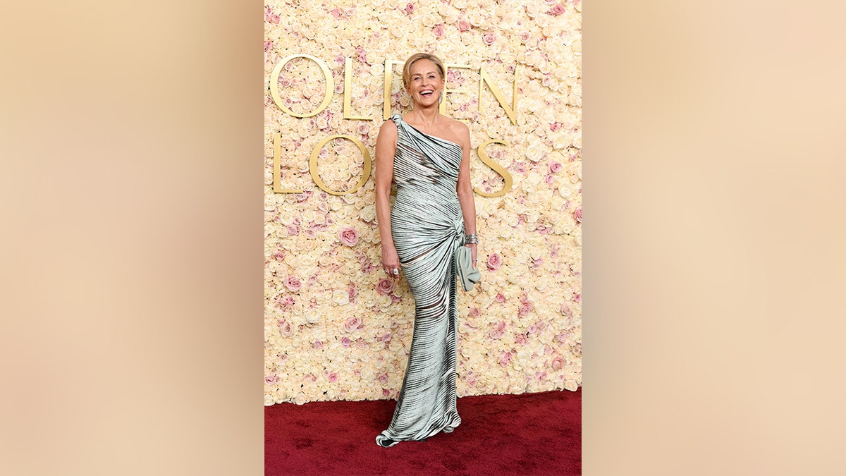 Sharon Stone wore a one-shoulder blue gown with black mixed in and a knot tied on the side to the 2025 Golden Globe Awards.