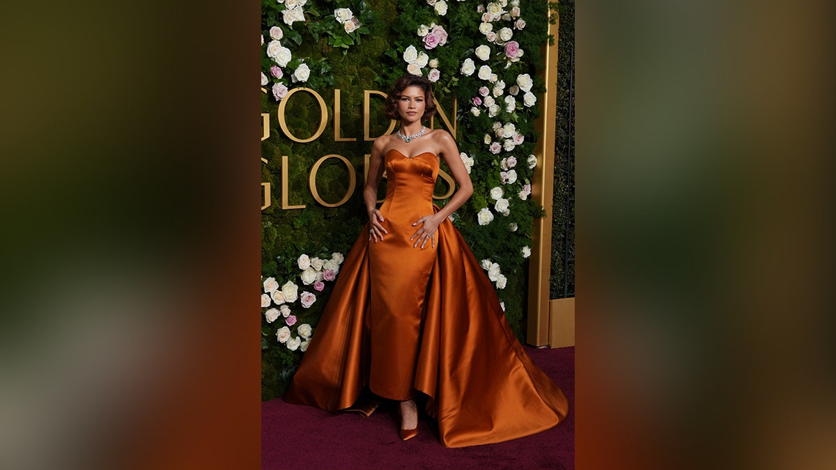 Zendaya shut down the red carpet in a strapless orange gown with a flowing train.