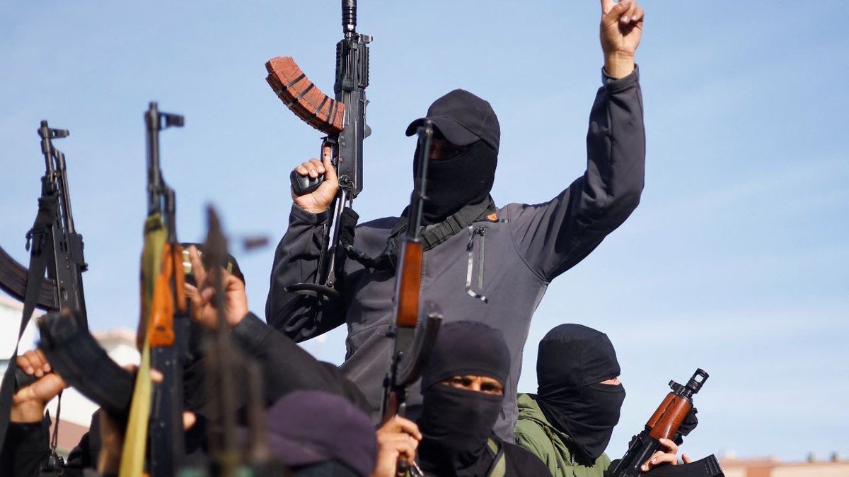 Terrorists with weapons raised in the air.