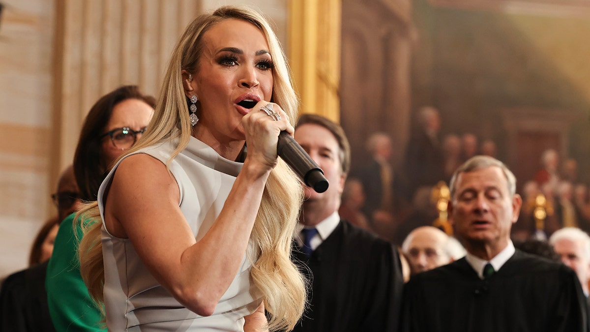 Carrie Underwood successful  a silver/grey formal  performs "America The Beautiful" astatine  the inauguration of President Trump