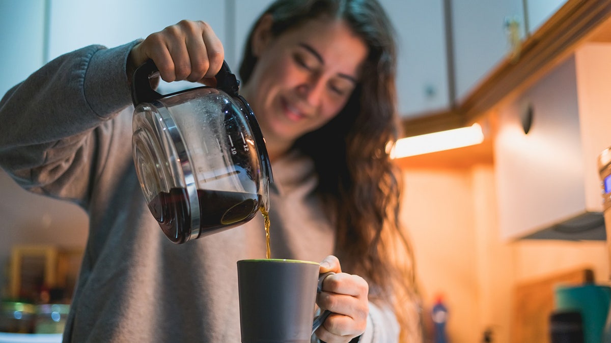 woman pouring coffee into mug