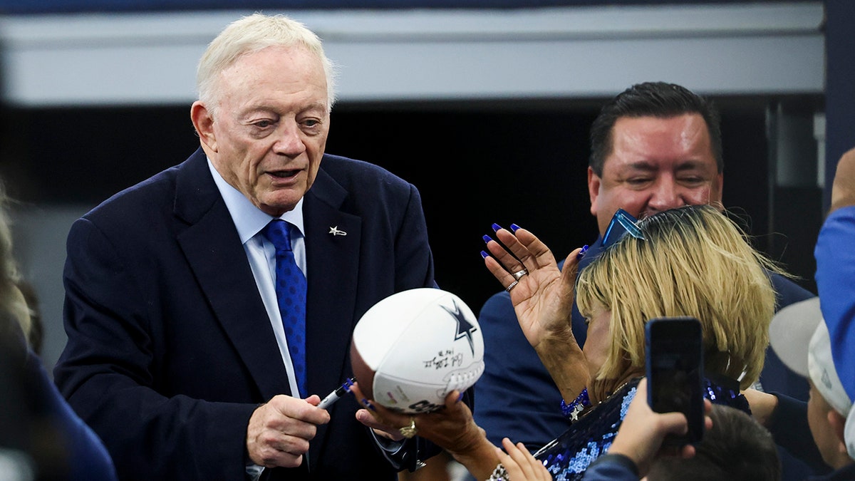 Jerry Jones signs autographs