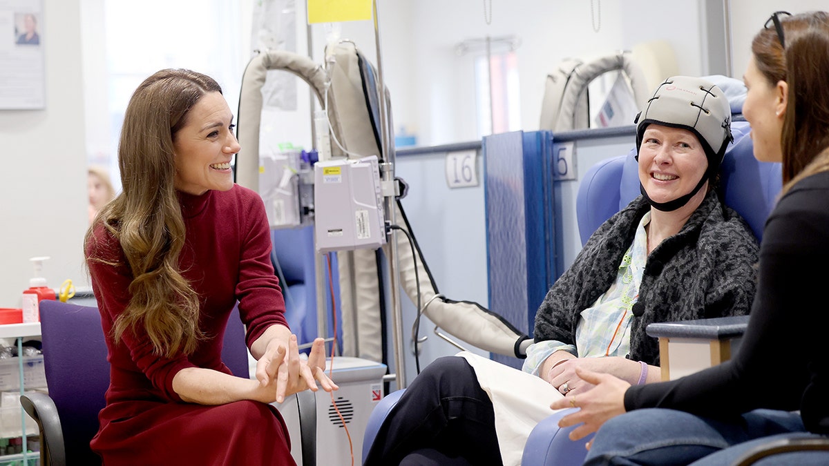 Kate Middleton wearing a burgundy dress and speaking with cancer patients.