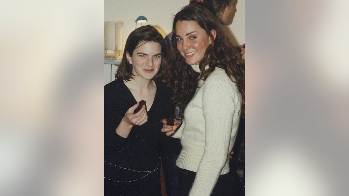 Laura Warshauer wearing a black long-sleeved sweater standing next to Kate Middleton wearing a white long-sleeved sweater