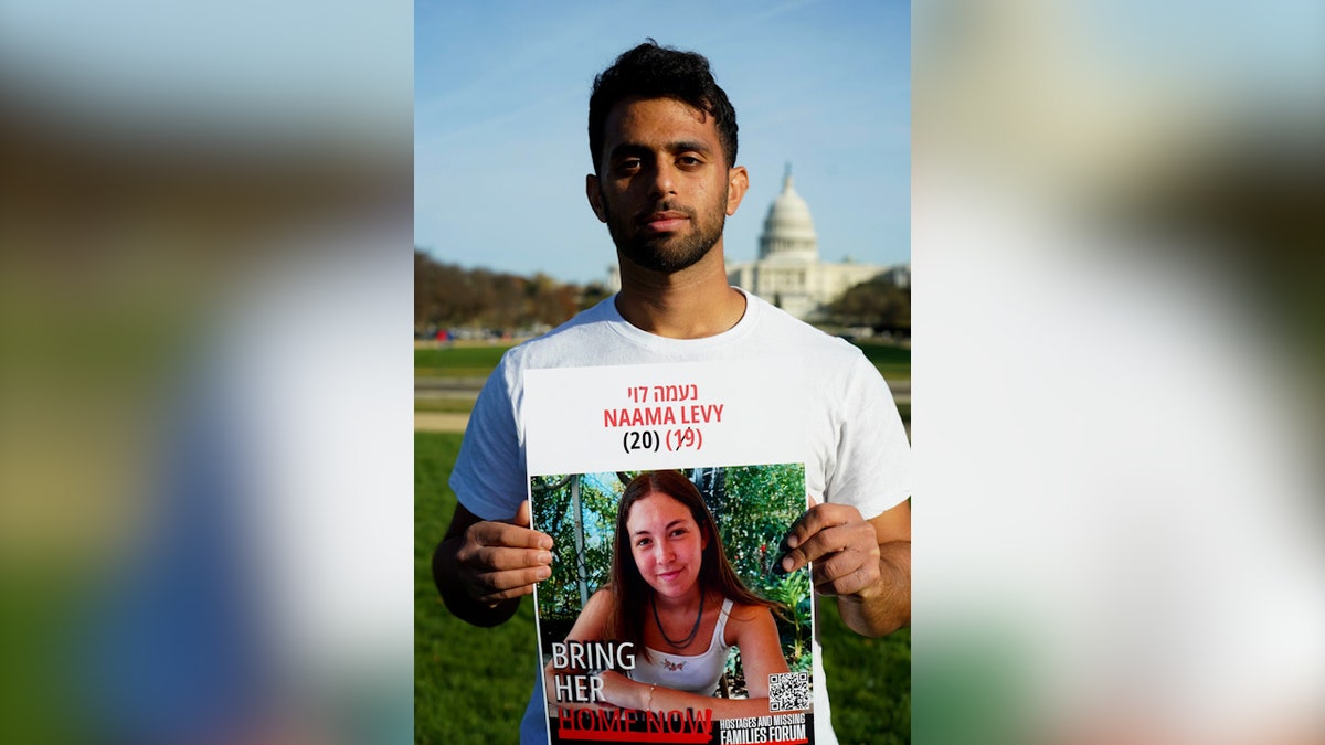 Amit Levy holds up a picture of his sister, Naama, in front of the U.S. Capitol at the March to Bring Them Home on Dec. 8. 2024.