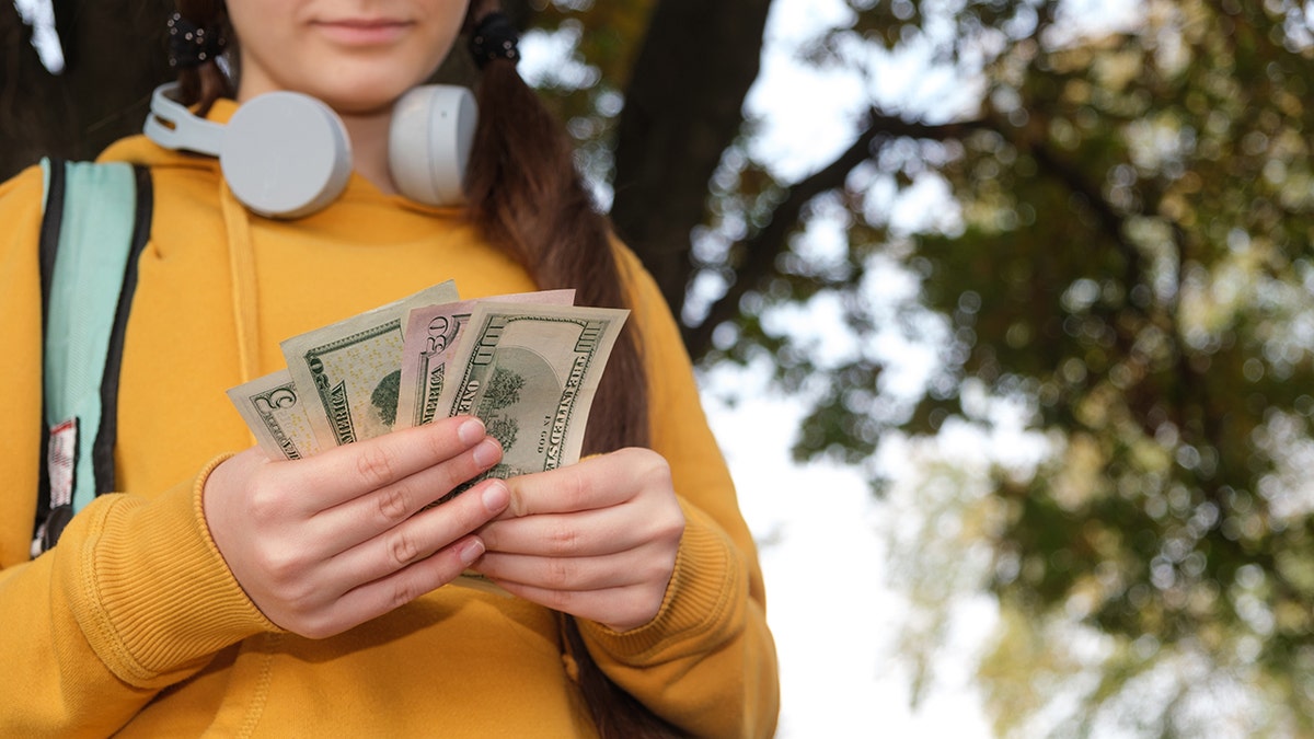 A little girl carrying money from her parents