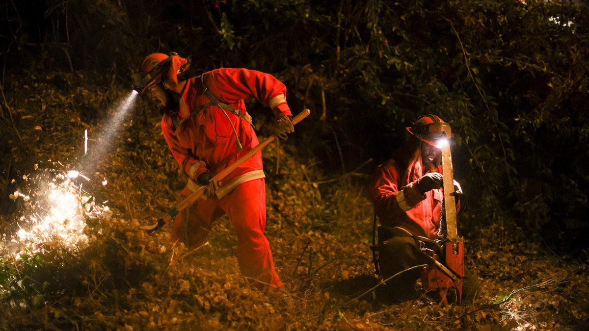 A California Department of Corrections hand crew works containment lines ahead of the Palisades Fire