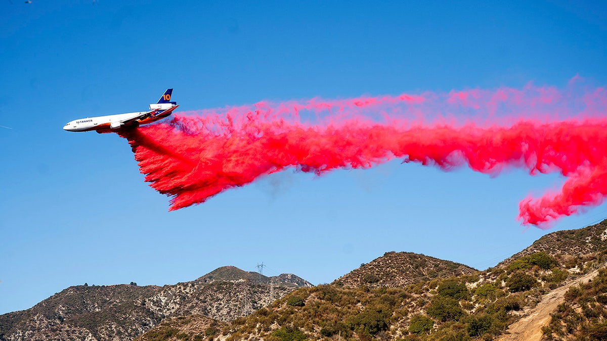 A retardant drops as an air tanker works to contain the Eaton Fire