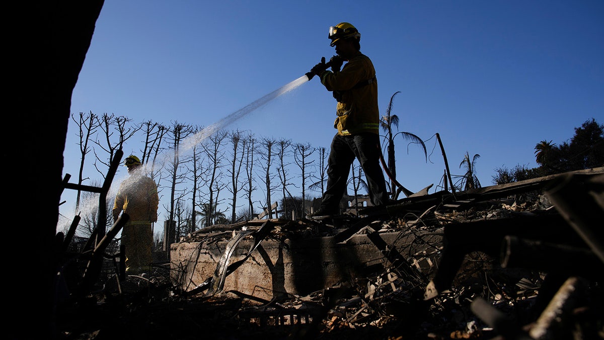 Tim Murphy, dari Departemen Pemadam Kebakaran San Francisco, memadamkan titik panas di properti yang terbakar setelah Kebakaran Palisades