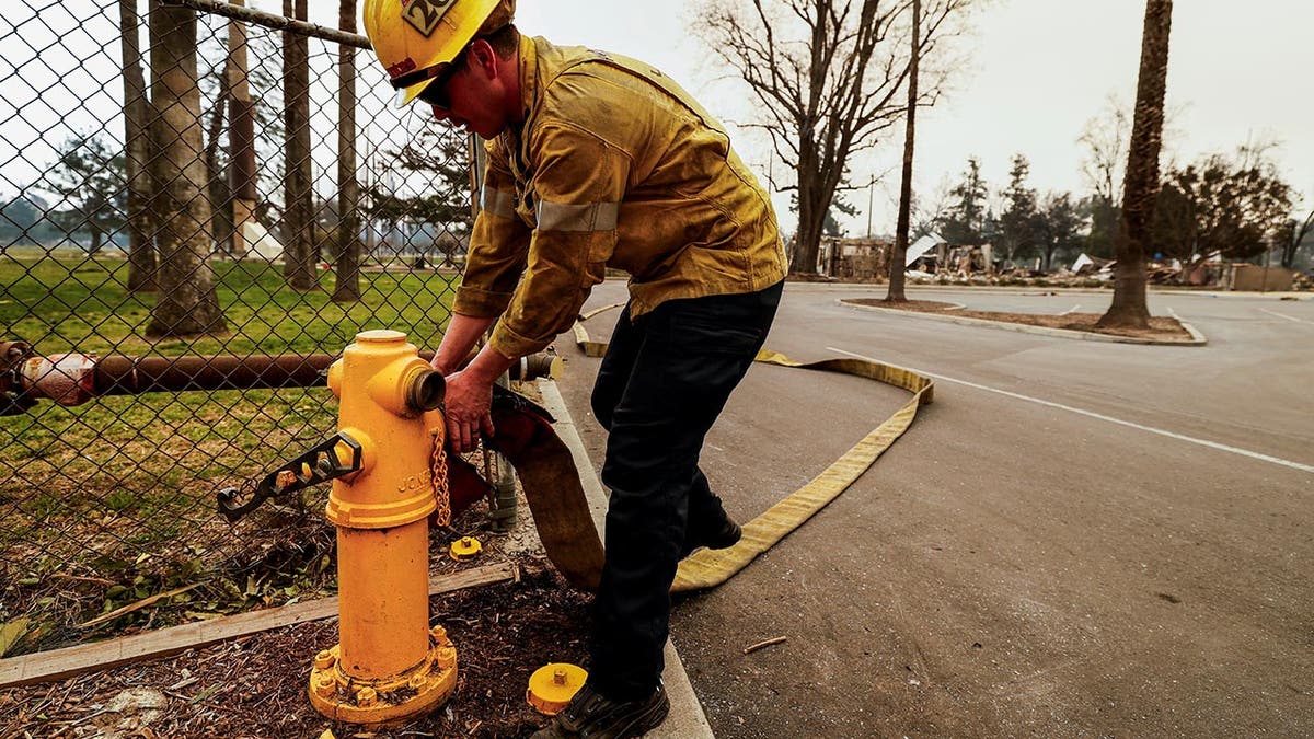 A firefighter operates a water hydrant