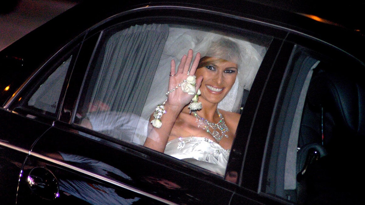 Melania Trump in her wedding dress waves after marrying Donald Trump