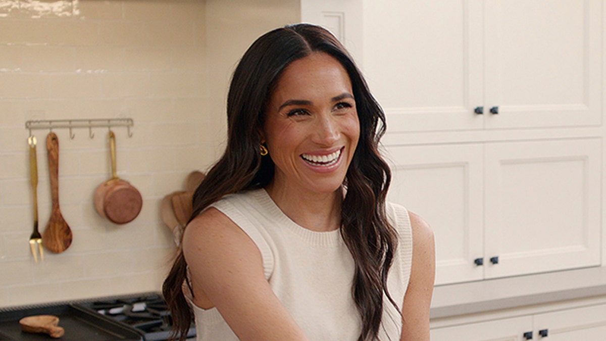 Meghan Markle laughed near the stove at home.