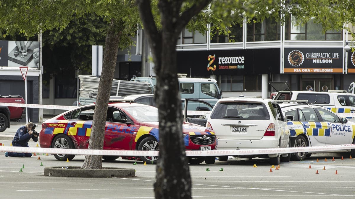 Los agentes forenses de la policía fotografían la escena del crimen en Buxton Square.