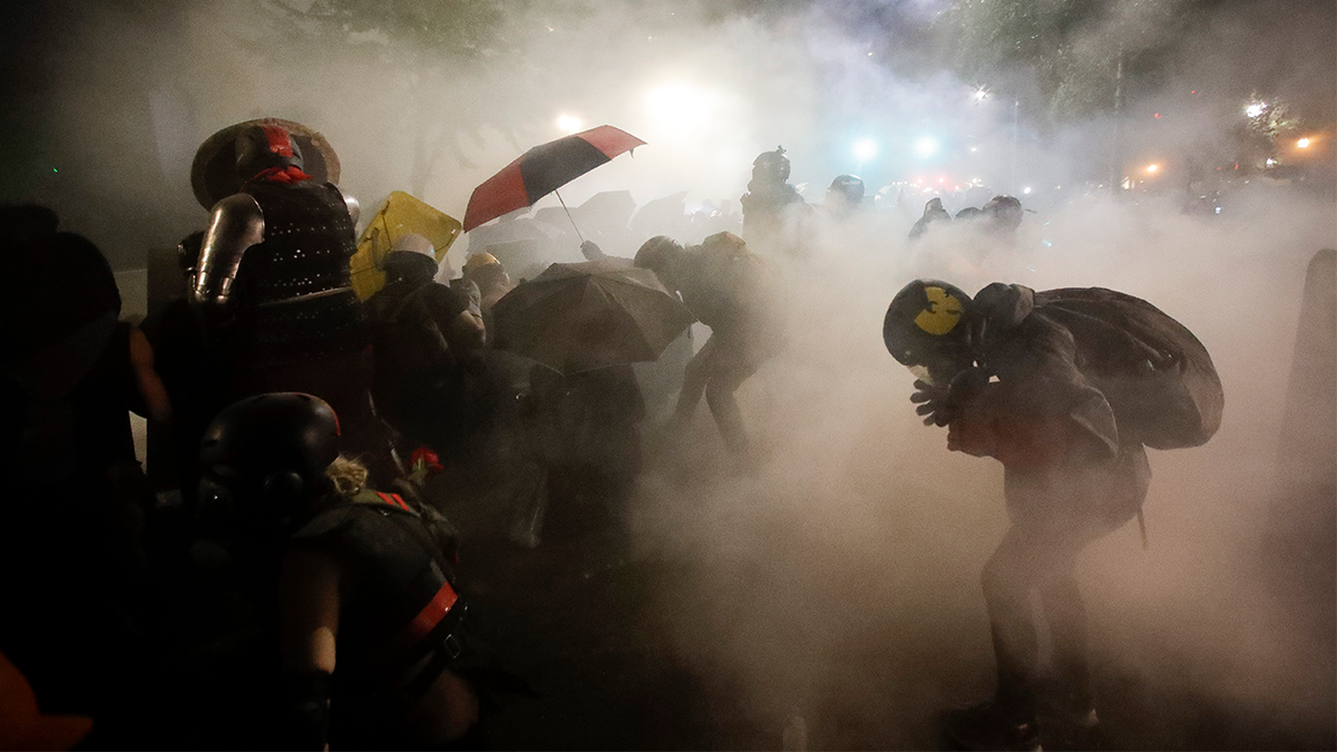 Federal officers fire tear gas at a group of demonstrators