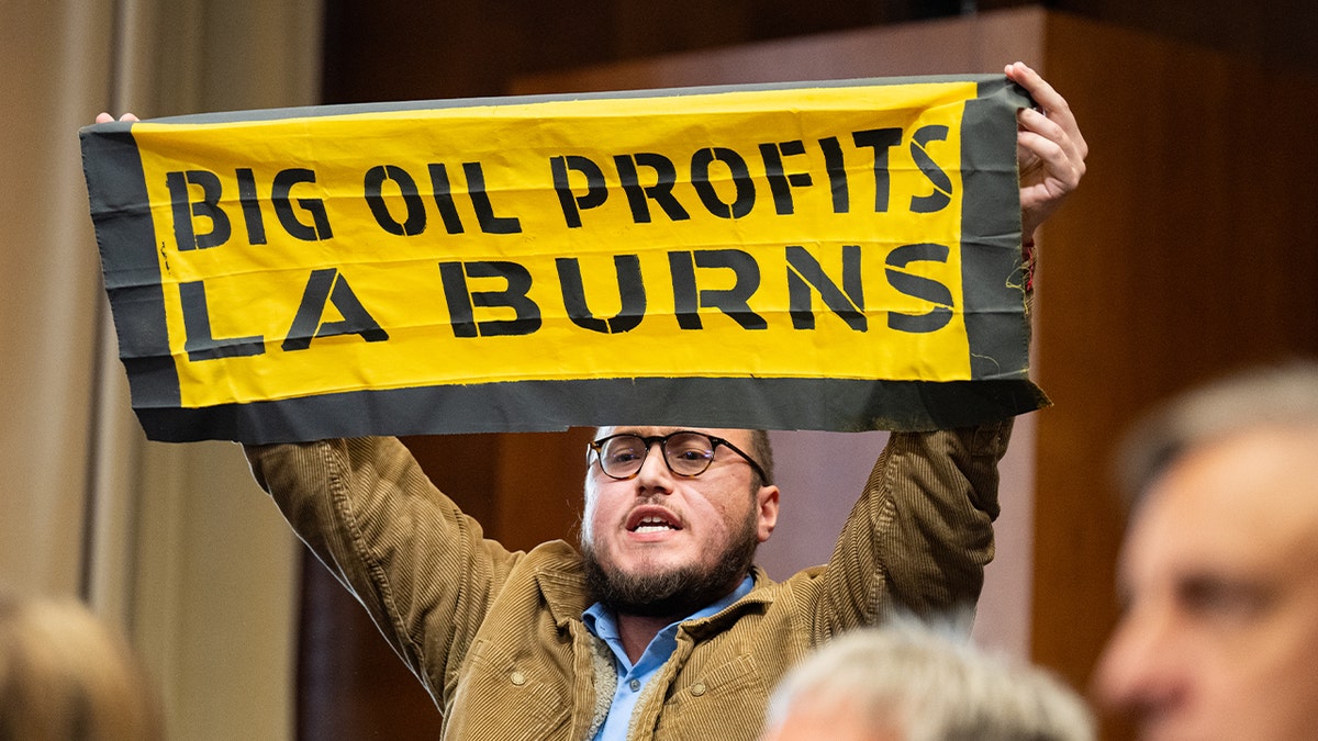 climate protester holding sign above his head