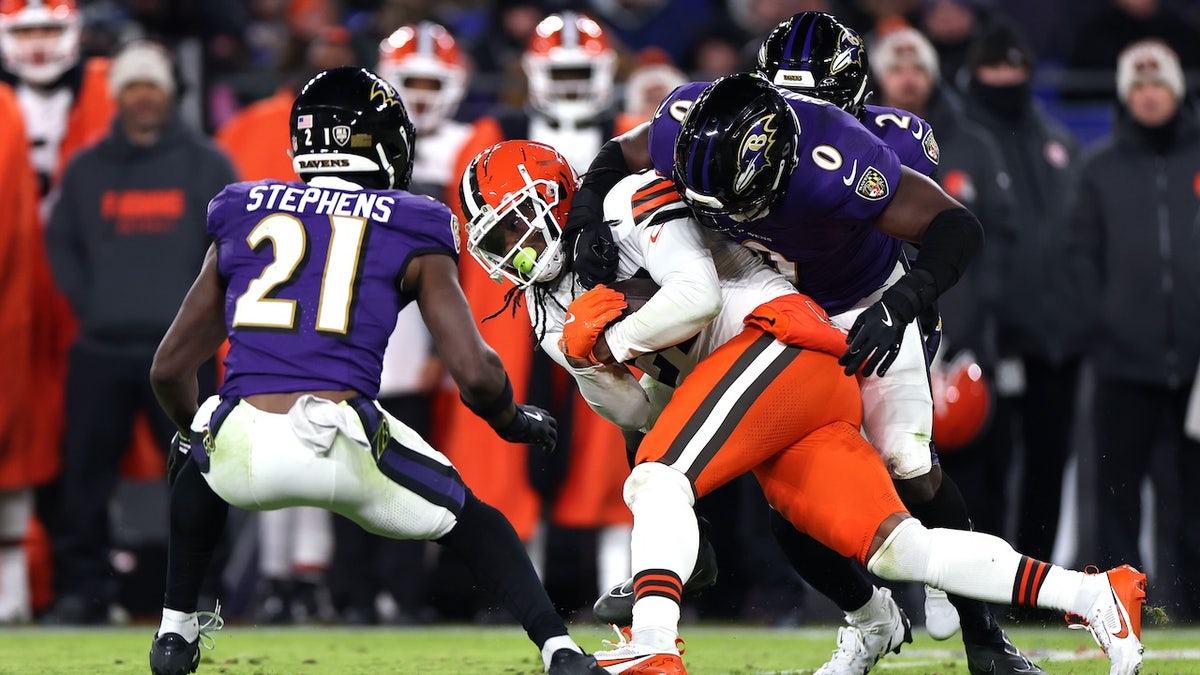 D'Onta Foreman (27) dari Cleveland Browns ditangani oleh Roquan Smith (0) dari Baltimore Ravens pada kuarter kedua di Stadion M&T Bank 4 Januari 2025, di Baltimore. 