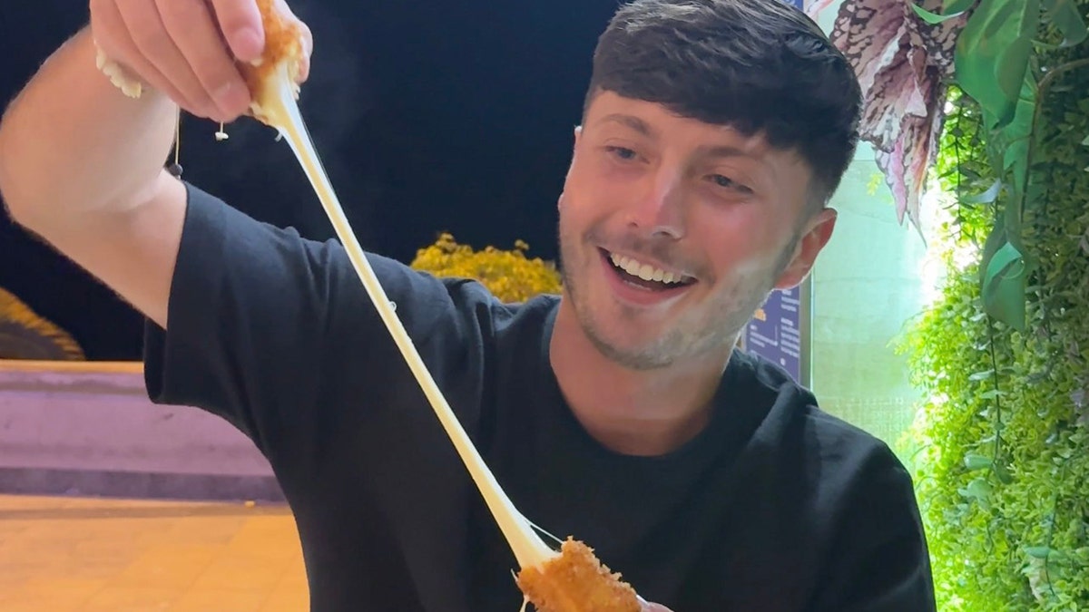 Man pulling apart mozzarella stick.