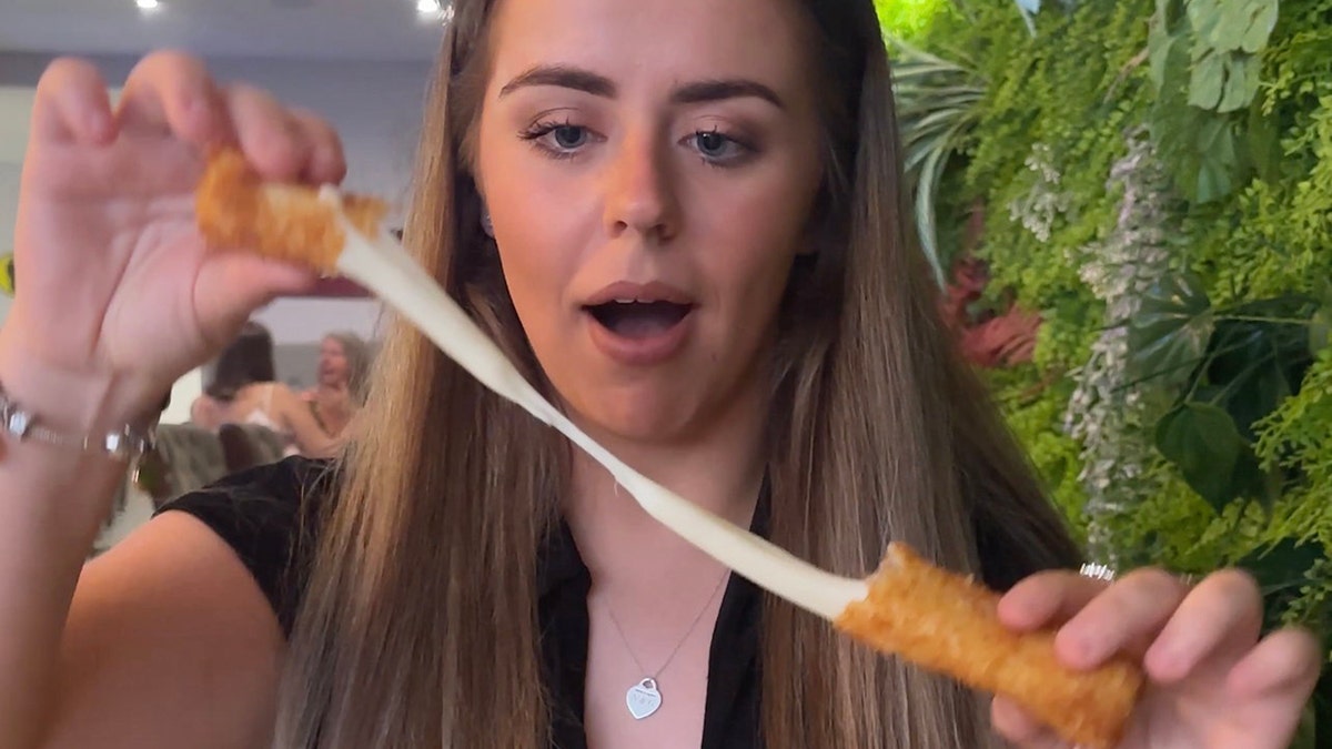 Grace Gonzalez takes apart a mozzarella stick.