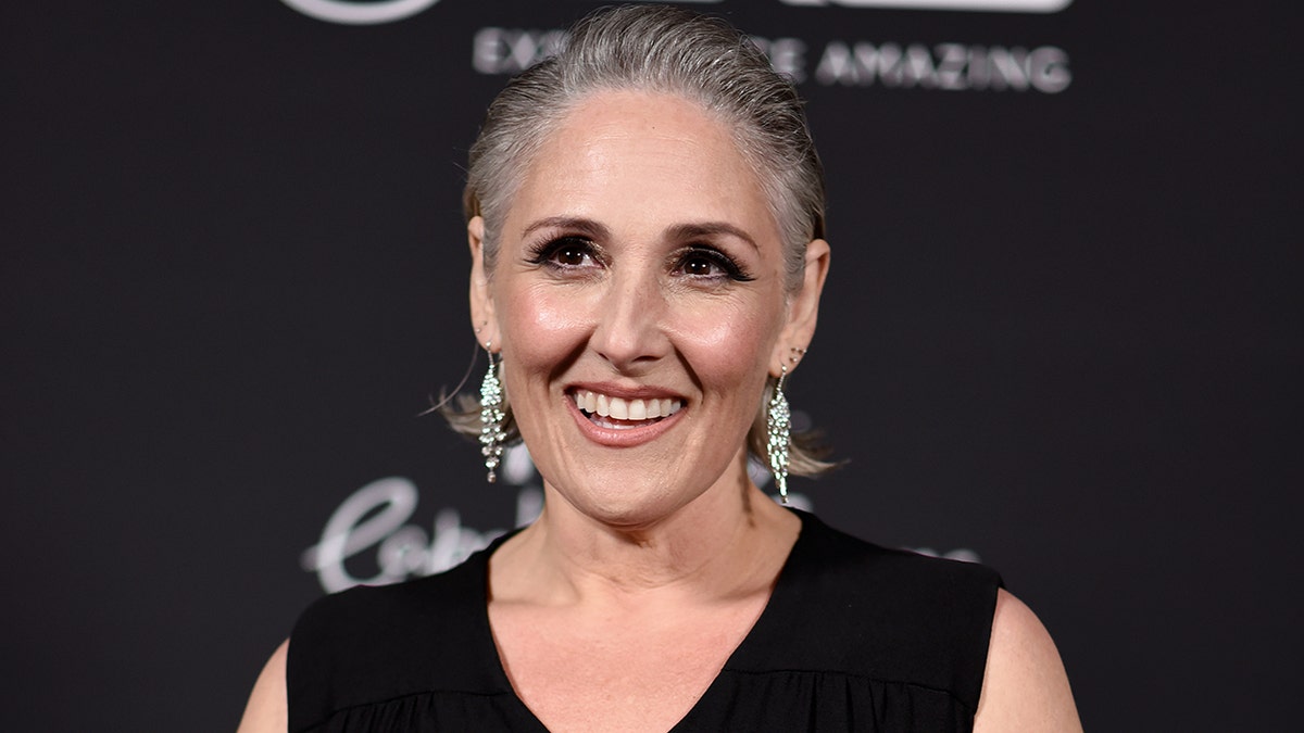 Ricki Lake smiles and looks slightly to her right on the carpet