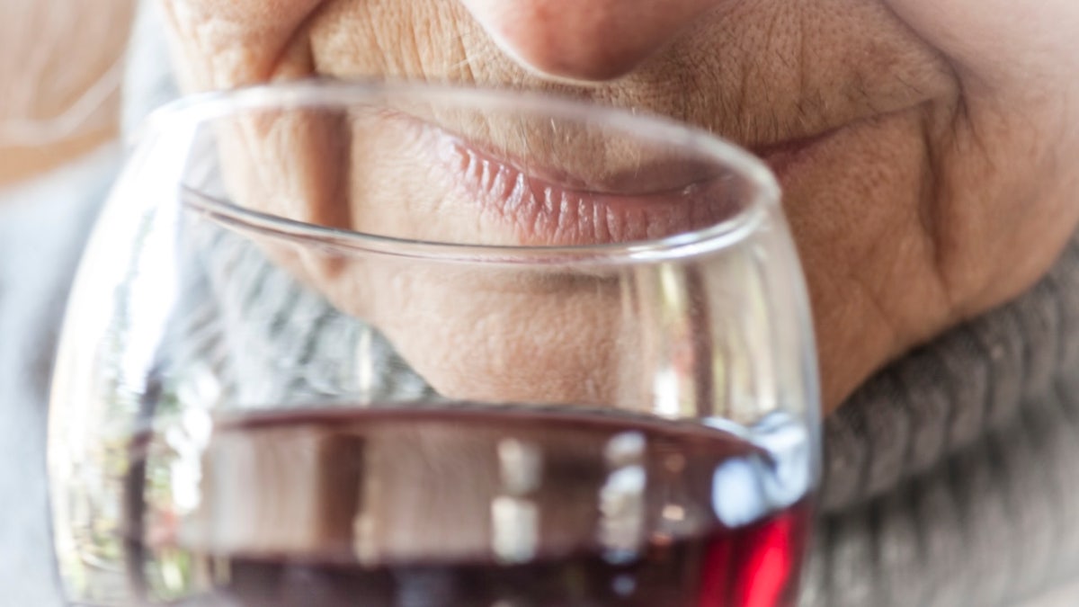 A senior woman enjoying a glass of wine.