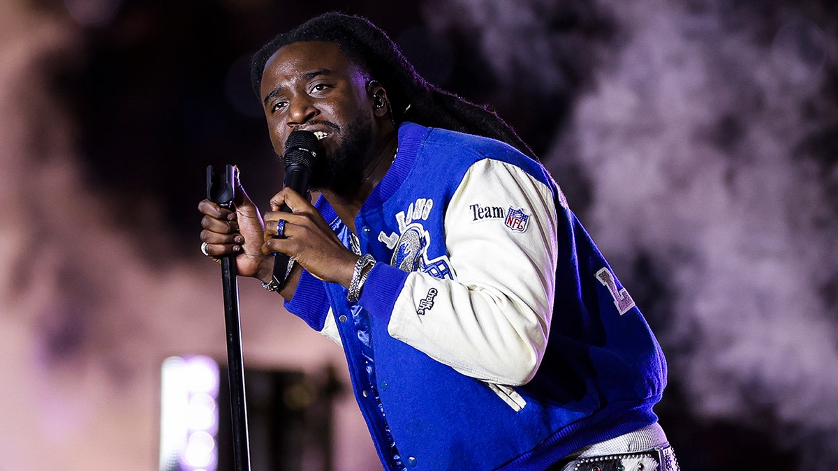 Shabz sings on stage wearing Detroit Lions letterman jacket