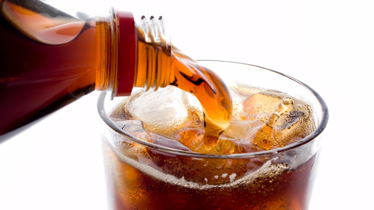 The soda is poured into a cup with snow.