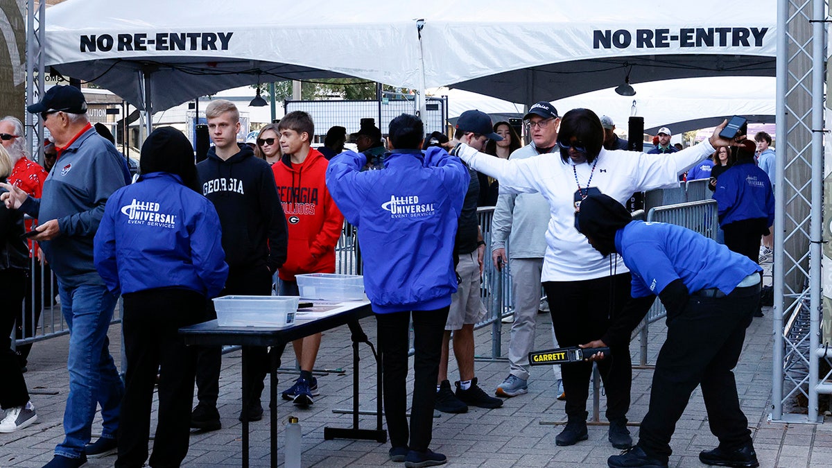 Fans pass through security check points as they enter the Caesars Superdome fan zone ahead of the Sugar Bowl NCAA College Football Playoff game, Thursday, Jan. 2, 2025, in New Orleans.