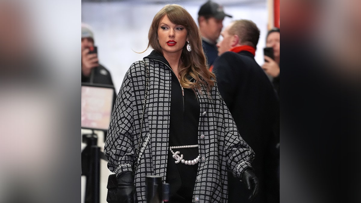 Taylor Swift in a Chanel grey and black jacket with a CC chain belt walks into Arrowhead Stadiuj