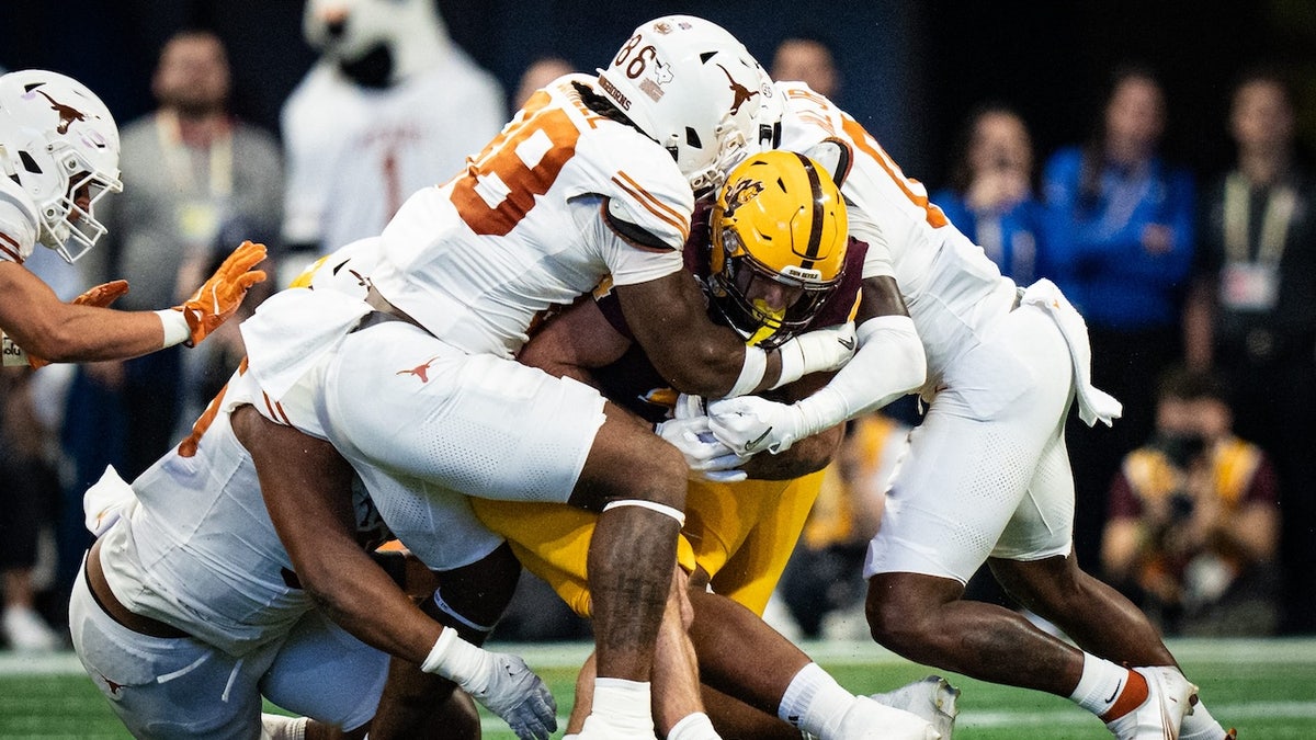 La defensa de Texas, incluido el liniero defensivo de los Texas Longhorns, Dorian Black (86), detiene al corredor de los Arizona State Sun Devils, Cam Skattebo (4), en el primer cuarto mientras los Texas Longhorns juegan contra los Arizona State Sun Devils en los cuartos de final del Peach Bowl College Football Playoff en Mercedes- Estadio Benz en Atlanta, Georgia, 1 de enero de 2025.