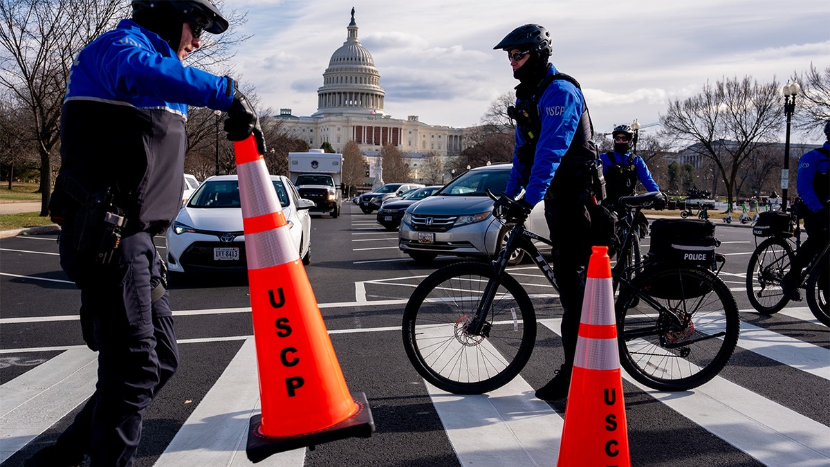 The Dome of the U.S. Capitol Building is visible as U.S. Capitol Police officers reopen a street after a driver was arrested for driving erratically and drove onto the grass near the Capitol Hill