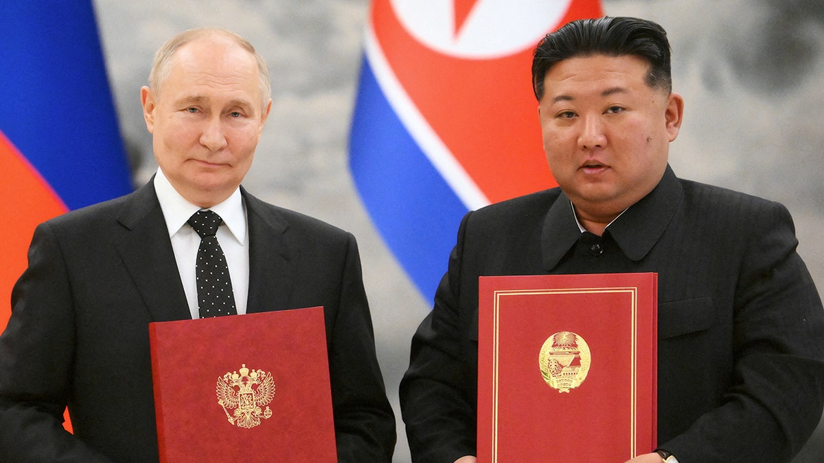 Russia's President Vladimir Putin and North Korea's leader Kim Jong Un pose for a photo during a treaty signing ceremony