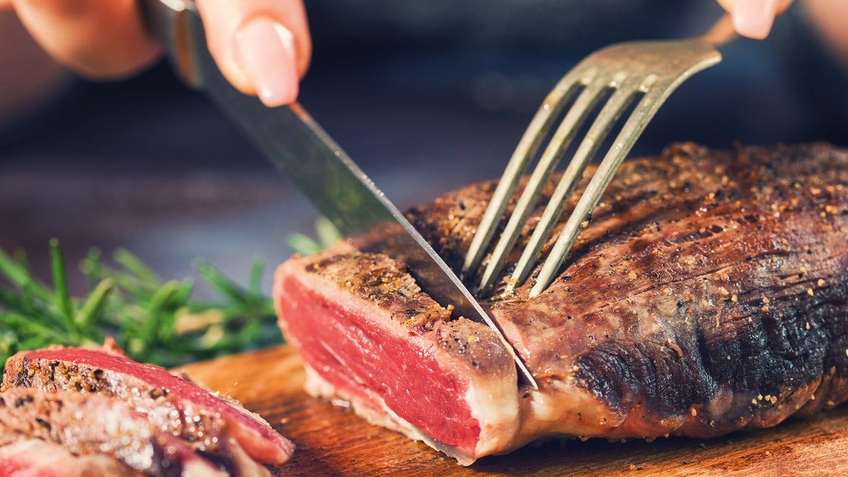 The woman cutting steak