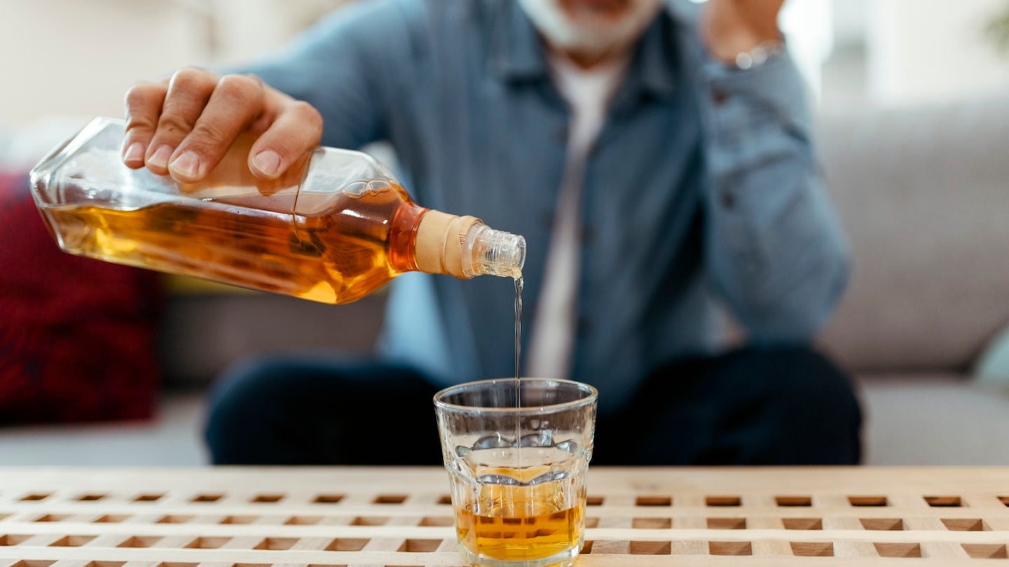 older man pouring whiskey